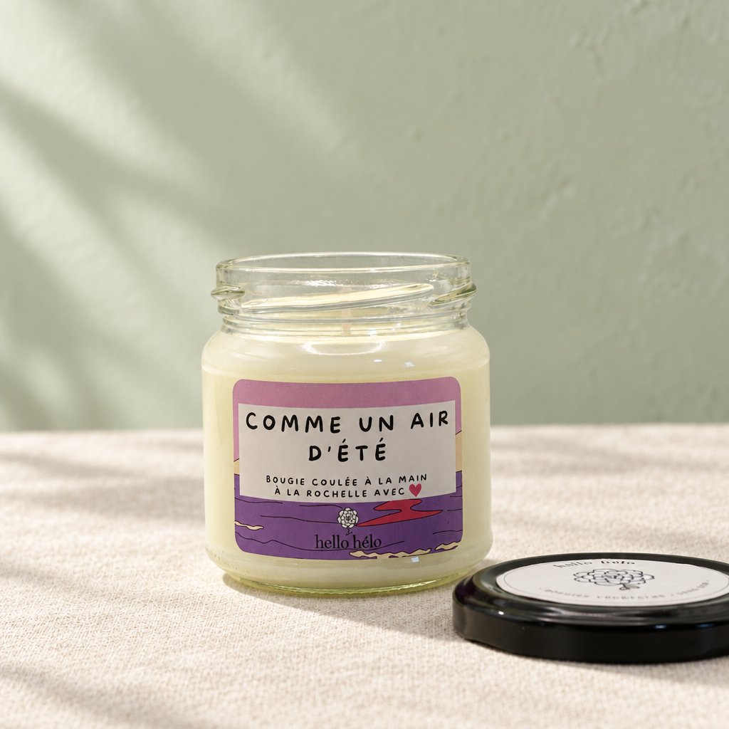 Bougie artisanale Comme un air d'été, pot en verre ouvert avec son couvercle noir posé à côté, sur un lin blanc devant un mur vert sauge